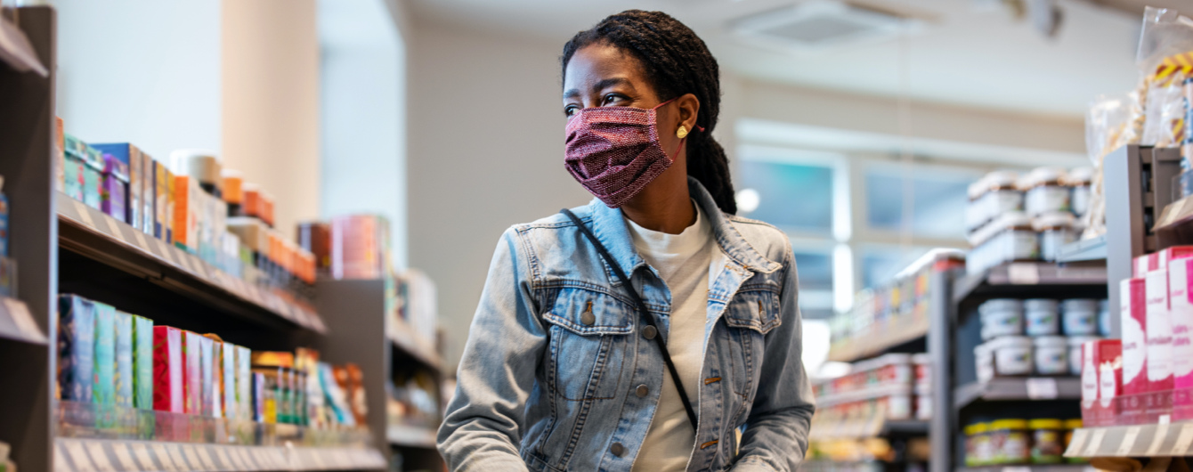 Frau kauft Marken von J&J Consumer Health, während sie eine Maske trägt