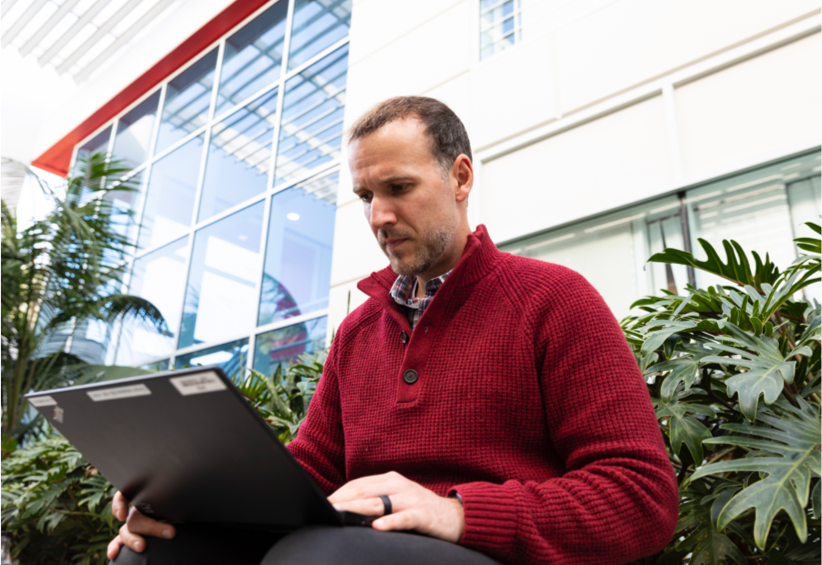 Man researching on laptop outdoors